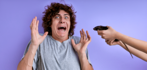homme brun frisé qui lève les mains et qui a peur d'un souris - hypnose phobies chambéry